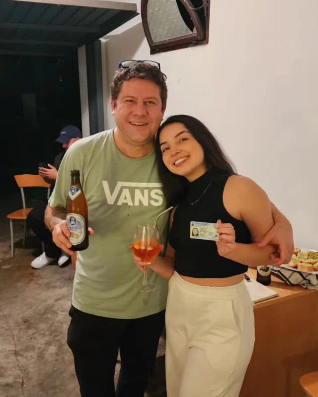 Casal de clientes da Speranza abraçados, ela segurando o documento de identidade italiano