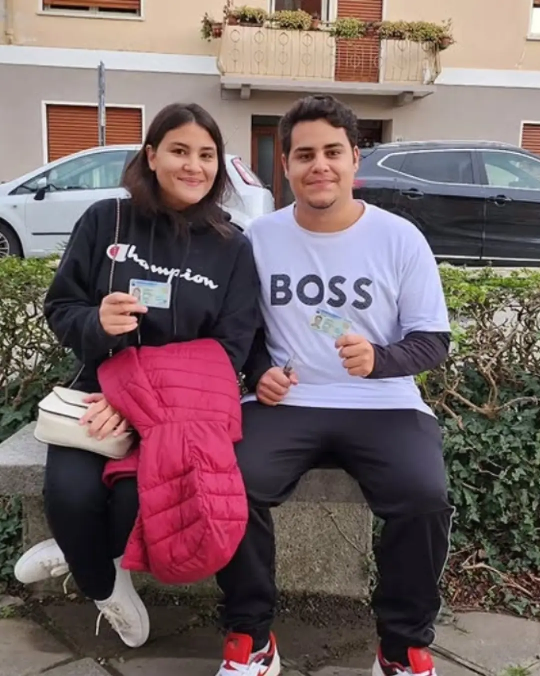 Casal jovem de clientes da Speranza sentados ao ar livre, segurando os documentos de identidade italianos
