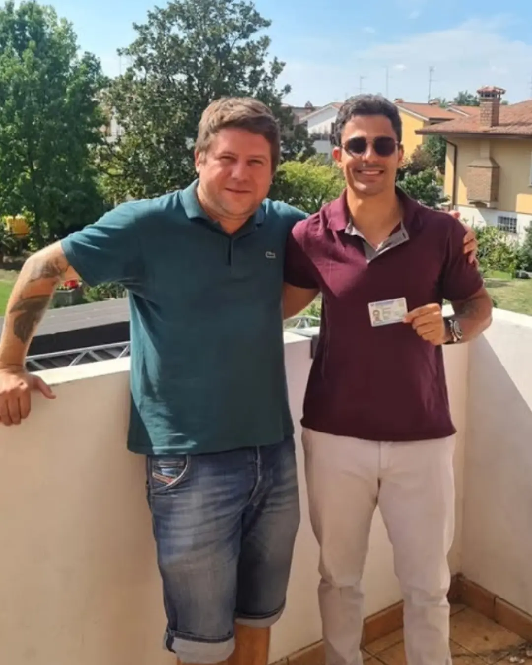 Dois clientes da Speranza em uma varanda, um segurando o documento de identidade italiano