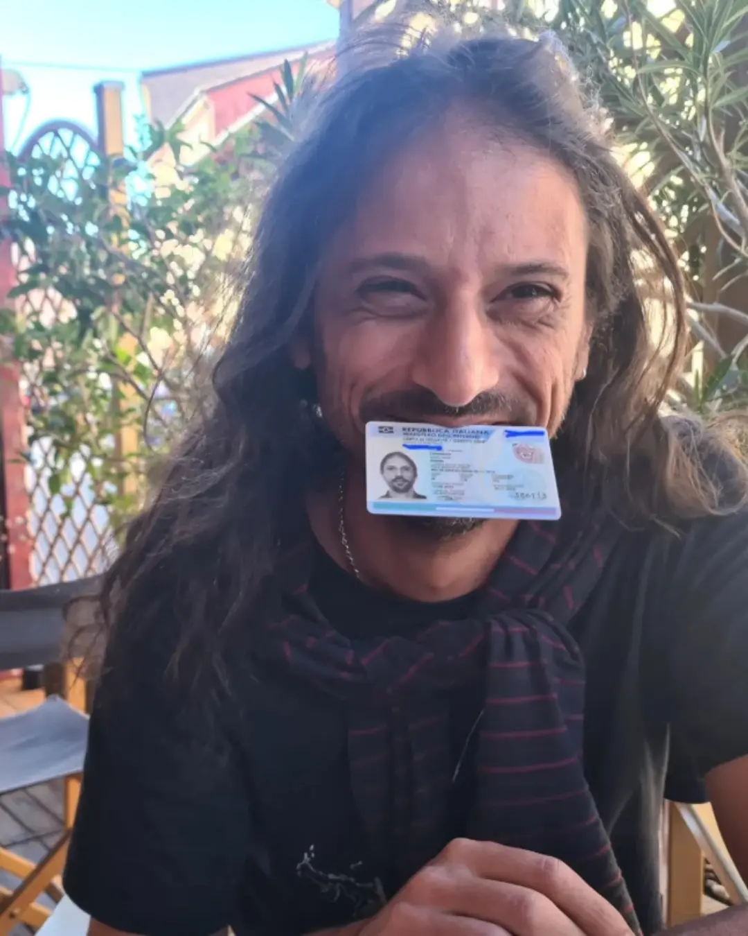 Cliente da Speranza sorrindo com o documento de identidade italiano