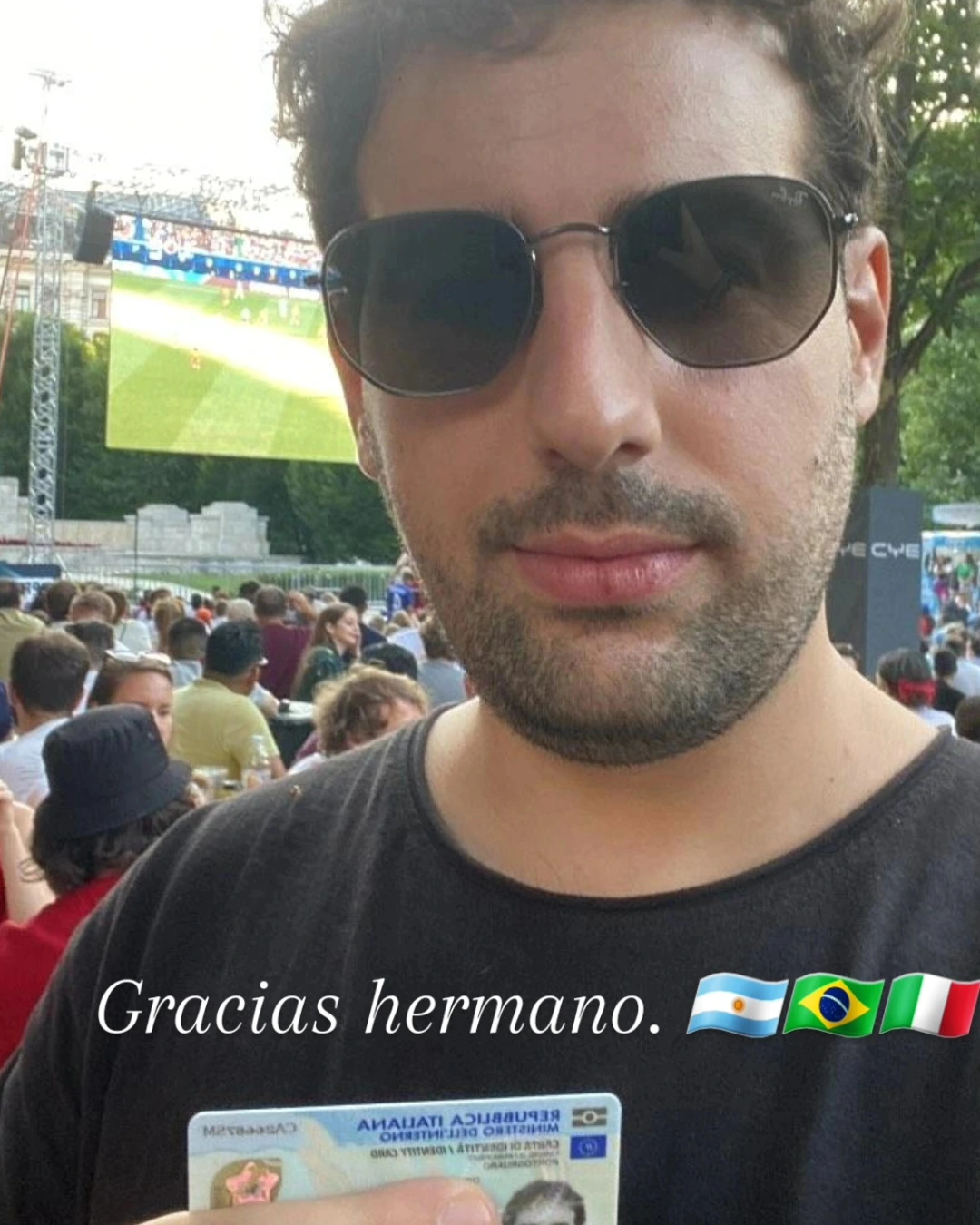 Cliente da Speranza comemorando em um evento ao ar livre, com o documento de identidade italiano recém-emitido