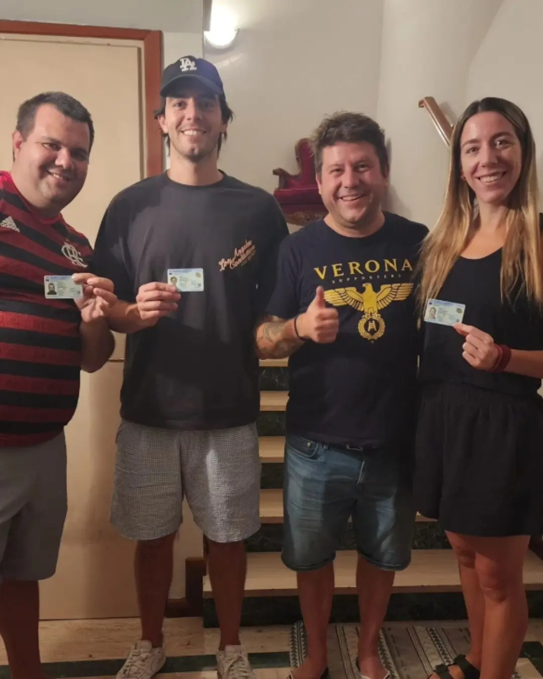 Quatro clientes da Speranza reunidos, segurando os documentos de identidade italianos