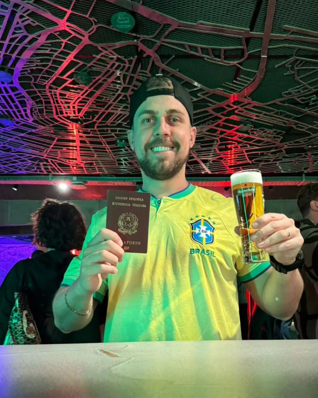 Cliente da Speranza brindando com o passaporte italiano em mãos